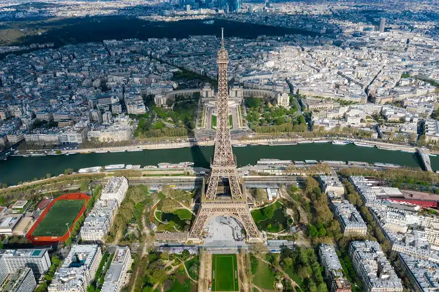 a tower and city with water and trees of Paris as best Europe Tour Packages