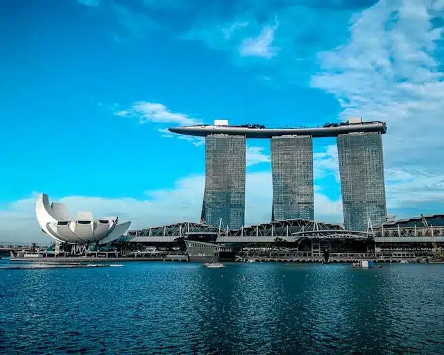 a large building next to a body of water with Marina Bay Sands in the background is to expect with your luxury tours agency