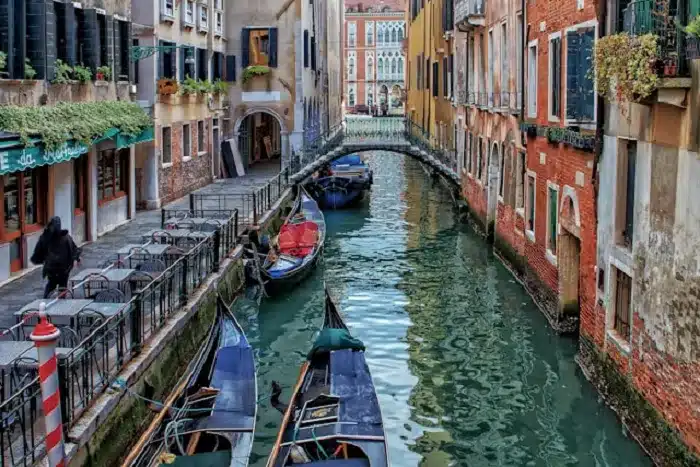 boats in a canal between buildings in the city of Venise