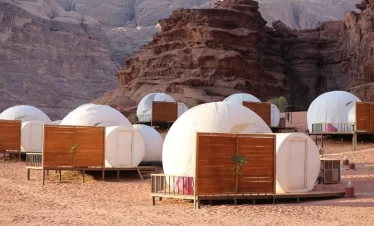 Tents are established in the desert, surrounded by sand dunes, illustrating a tranquil and remote outdoor setting in our Jordan itinerary 5 days