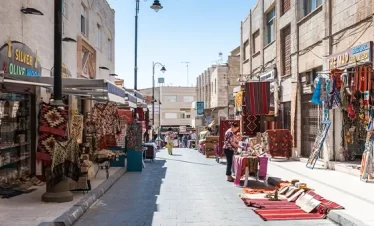 1. A bustling street filled with numerous pedestrians engaged in various activities as they walk along the pathway in our Jordan itinerary 5 days