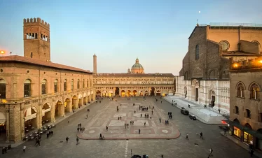 A spacious courtyard bustling with people leisurely walking and engaging in conversation with our Italy itinerary 14 days
