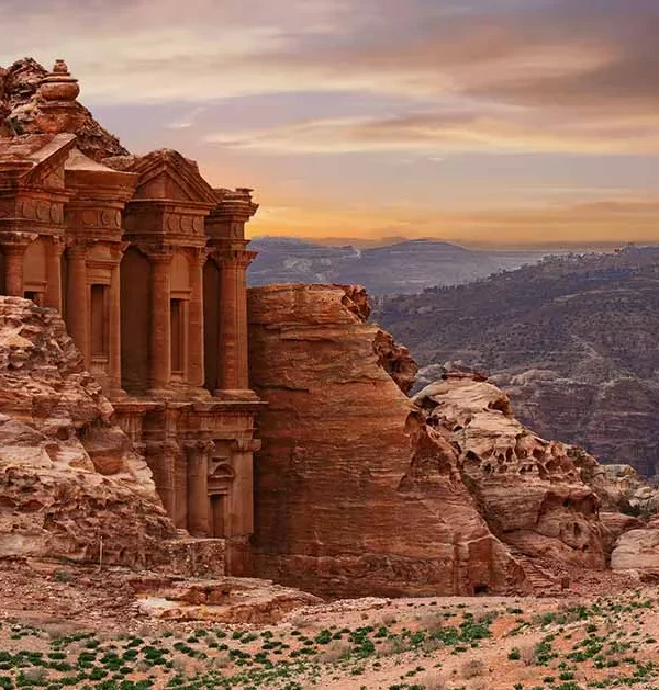 Monastery in Petra, Jordan, showcasing its grand facade carved into rock amidst a desert landscape. in our Jordan itinerary 10 days