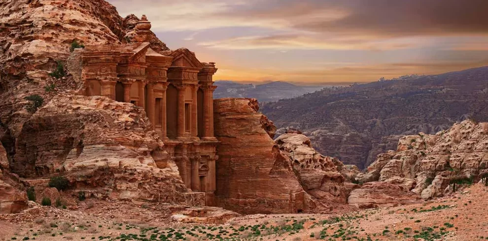 Monastery in Petra, Jordan, showcasing its grand facade carved into rock amidst a desert landscape. in our Jordan itinerary 10 days