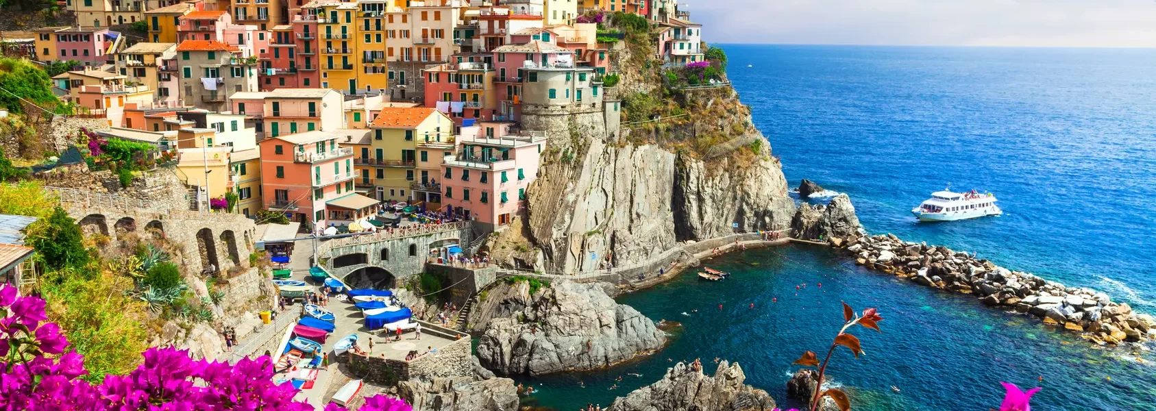 A picturesque Italian coastal village adorned with vibrant flowers, showcasing its natural beauty and charm while our Italy Itinerary 15 days