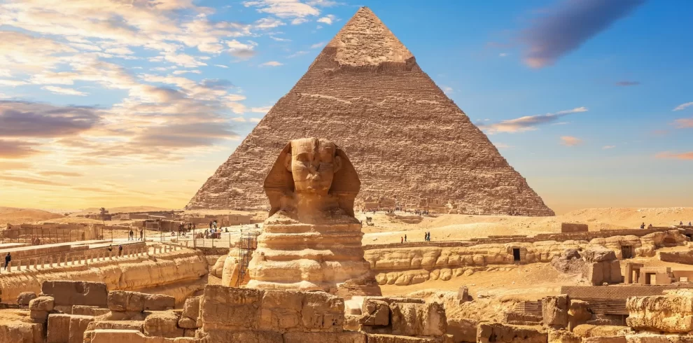 The Great Sphinx and the Pyramid of Giza silhouetted against a vibrant sunset sky with our Egypt itinerary 8 days