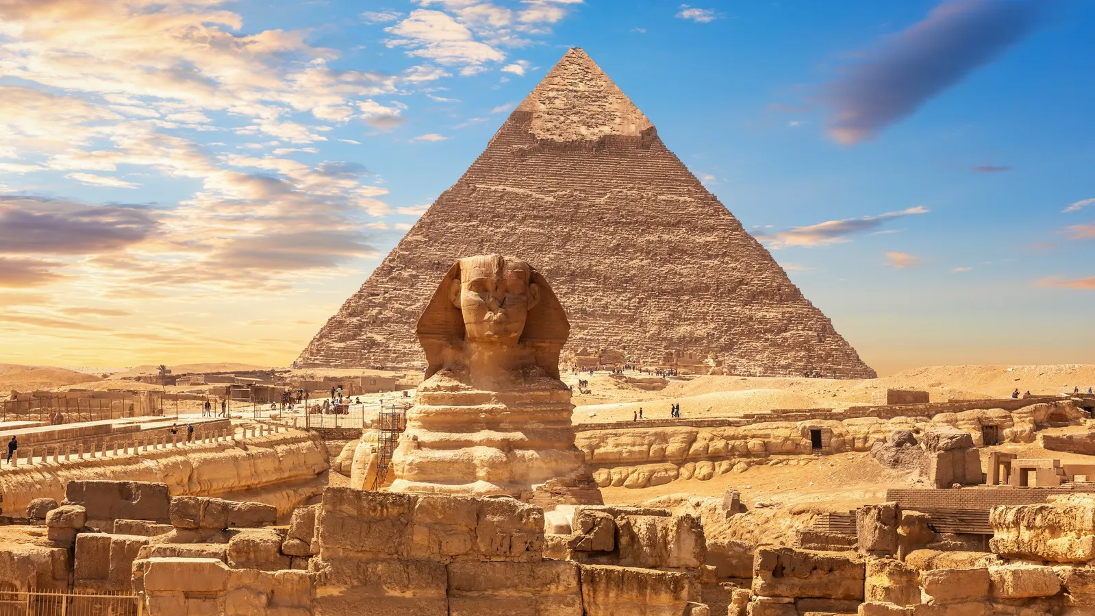 The Great Sphinx and the Pyramid of Giza silhouetted against a vibrant sunset sky with our Egypt itinerary 8 days