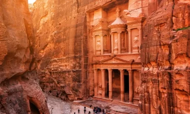 The Treasury of Petra, Jordan, showcasing its intricate facade carved into rose-red rock, surrounded by towering cliffs in Jordan itinerary 5 days