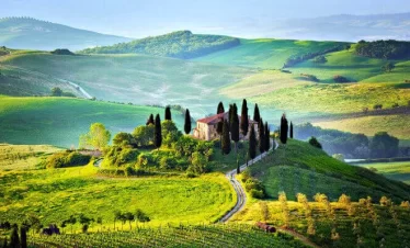 Rolling hills of Tuscany showcase a picturesque landscape, characterized by lush greenery and gentle slopes while your italian tour