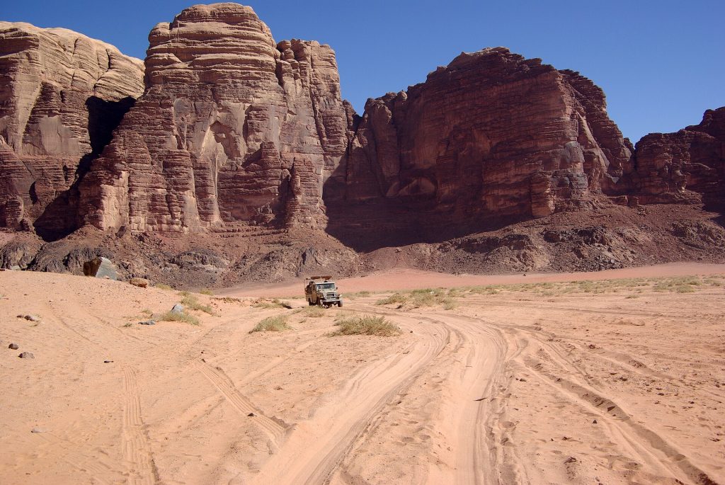 Jordan 5-Day Luxury Private Tour 15 Desert track below sandstone mountains in Wadi Rum, Jordan